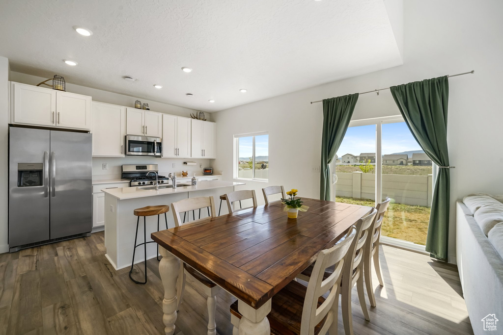 Dining room with wood finished floors and recessed lighting