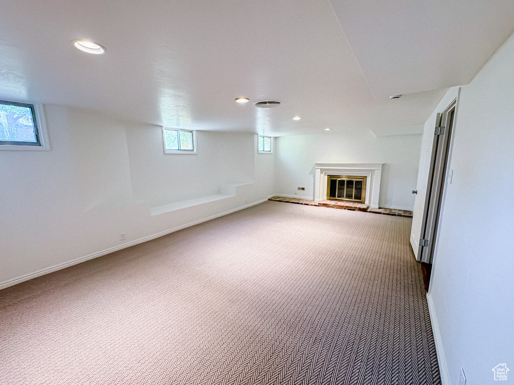 Basement featuring carpet, recessed lighting, a glass covered fireplace, and baseboards