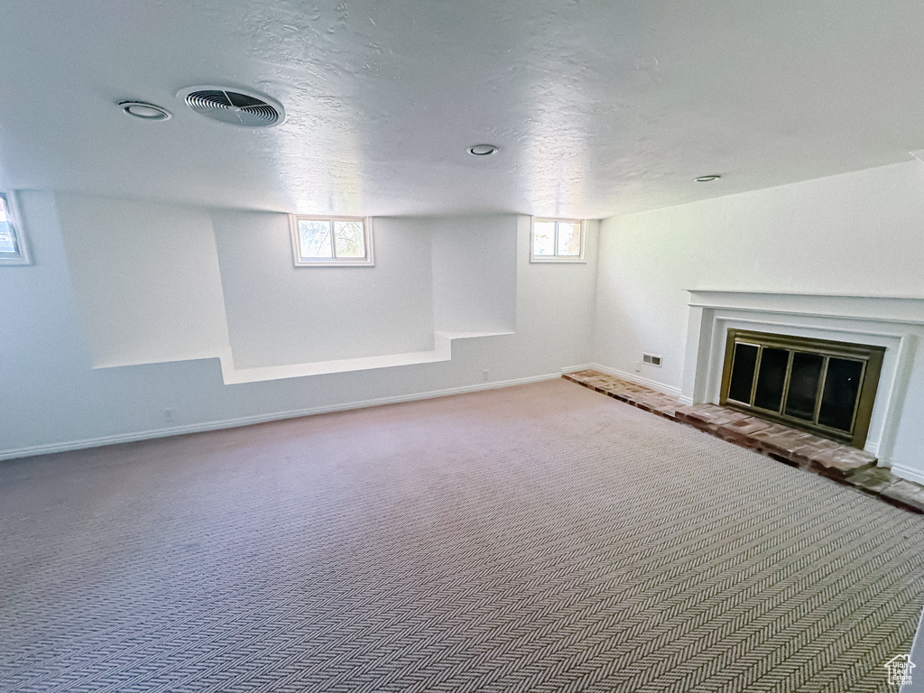 Below grade area featuring carpet flooring, baseboards, and a fireplace