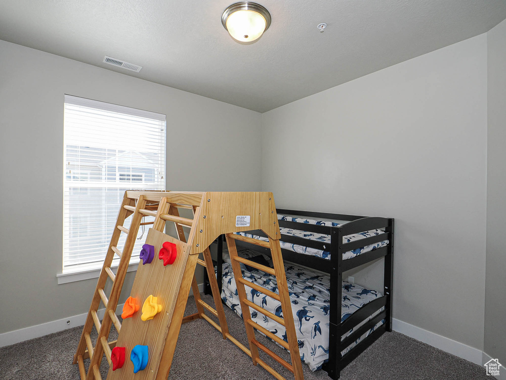 Bedroom featuring multiple windows, carpet, and baseboards