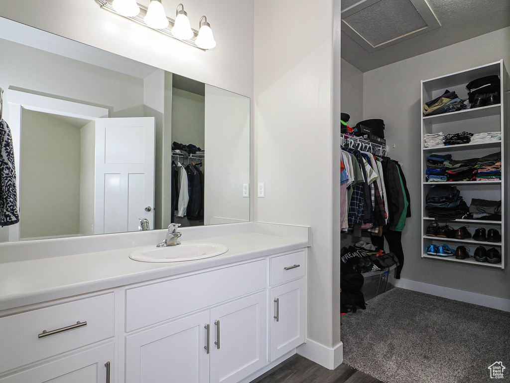 Bathroom with vanity, a walk in closet, and baseboards