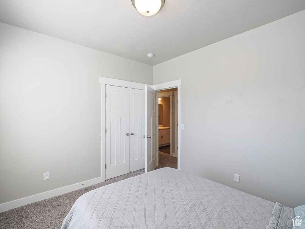 Bedroom with carpet flooring, baseboards, and a closet