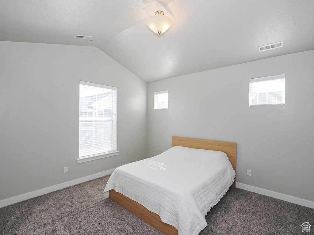 Bedroom featuring carpet, vaulted ceiling, and baseboards