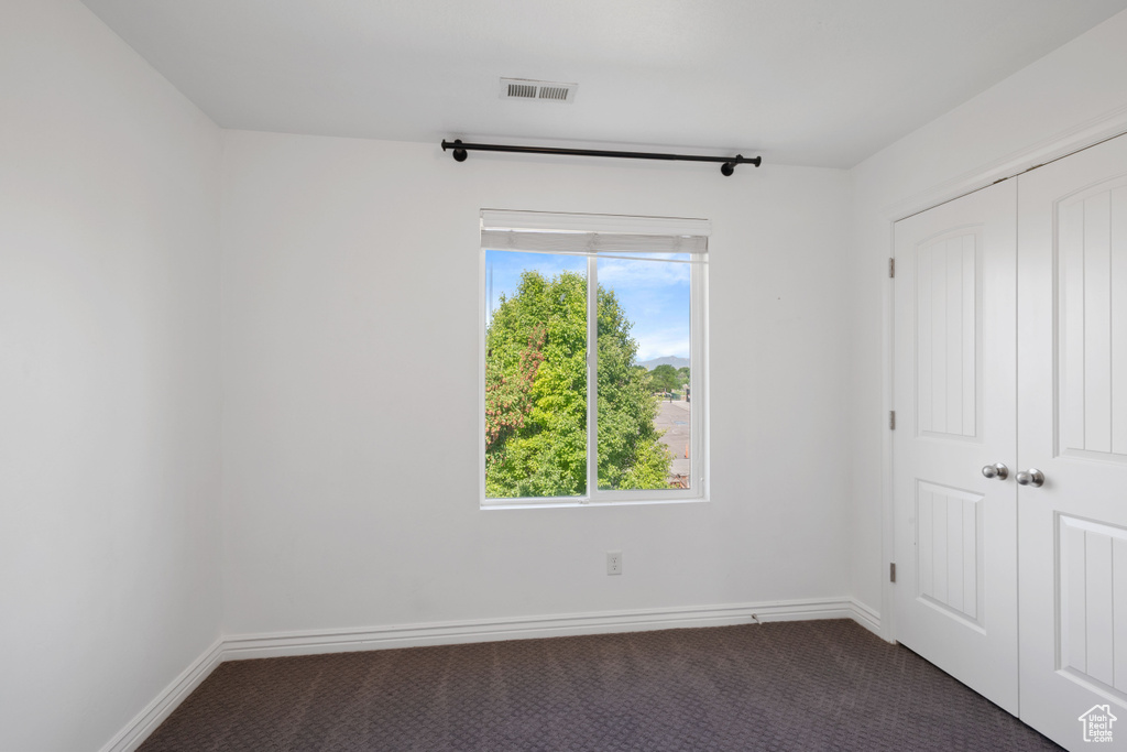 Unfurnished bedroom with carpet flooring, a closet, and baseboards