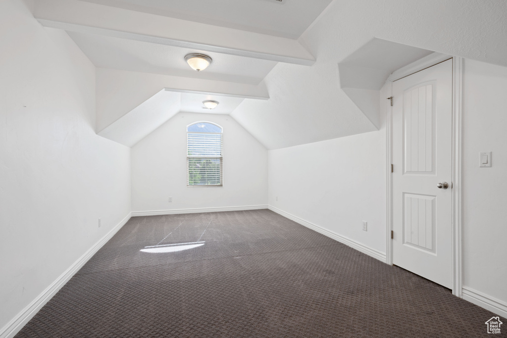 Bonus room featuring carpet floors, lofted ceiling, and baseboards