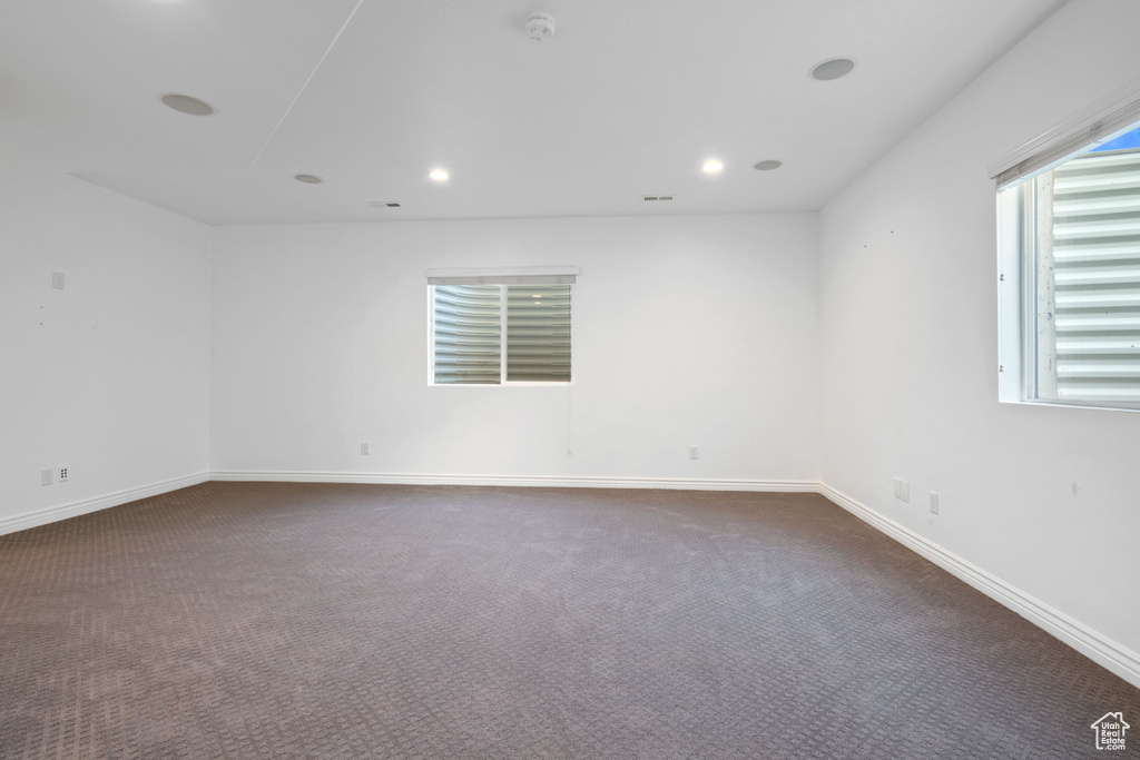Unfurnished room with dark colored carpet, baseboards, recessed lighting, and a smoke detector