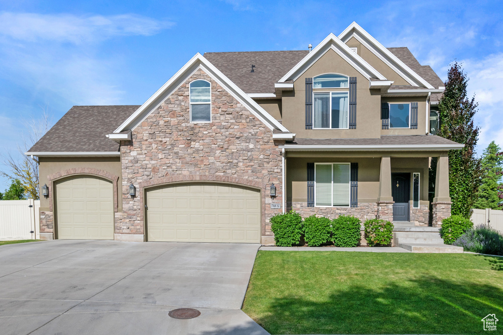 Craftsman-style home featuring stucco siding, stone siding, driveway, roof with shingles, and a garage