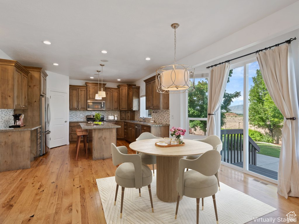 Dining area featuring light wood finished floors, recessed lighting, and a chandelier