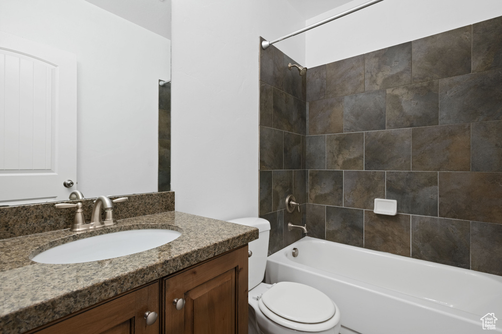 Full bathroom featuring toilet, vanity, and tub / shower combination