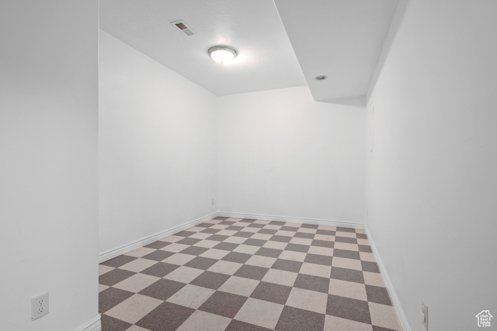 Unfurnished room featuring dark flooring and baseboards