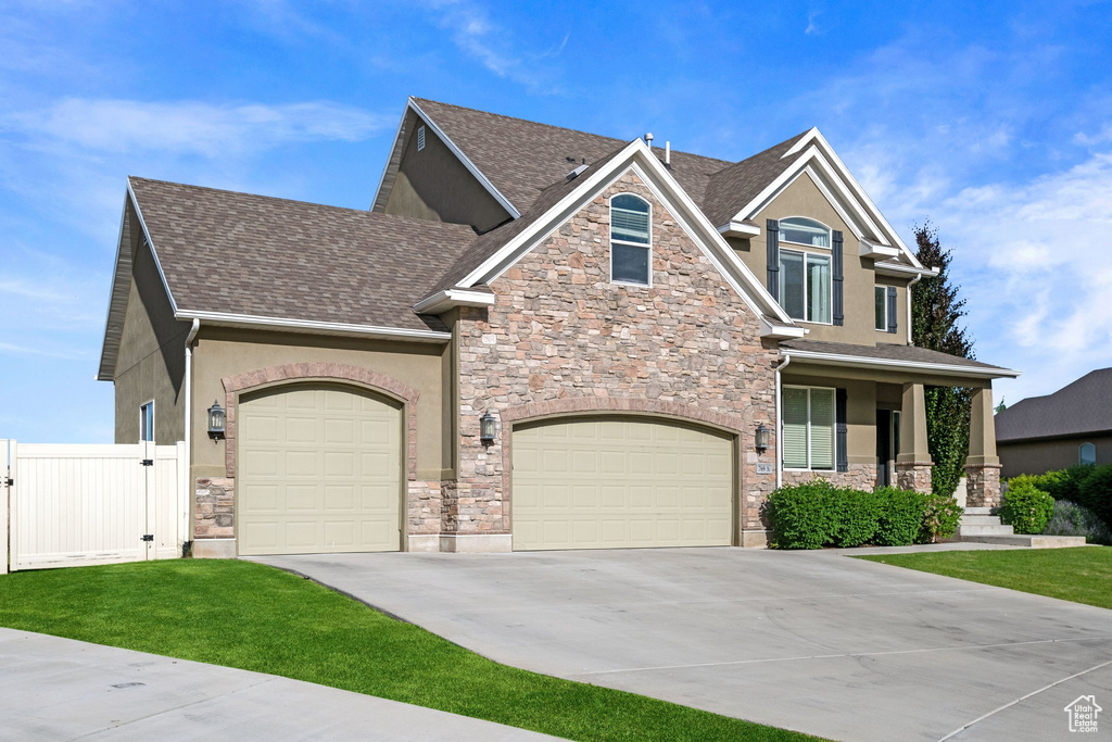 Craftsman house featuring stone siding, stucco siding, concrete driveway, and a shingled roof