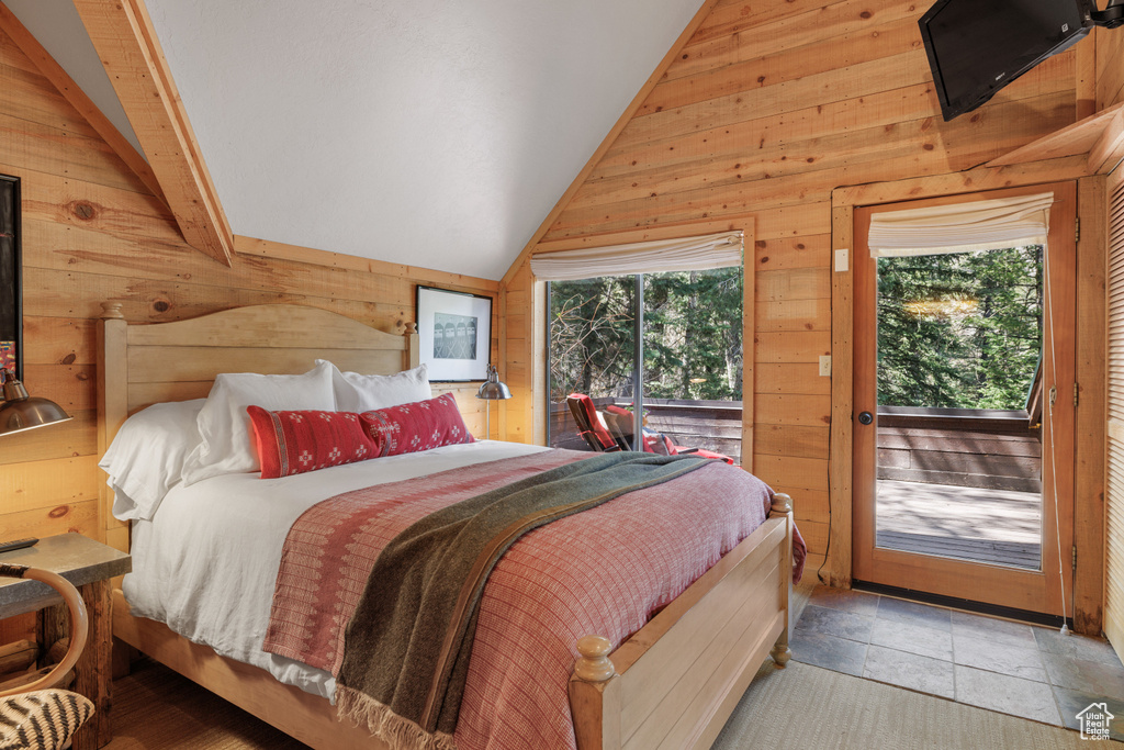 Bedroom with wood walls and access to outside