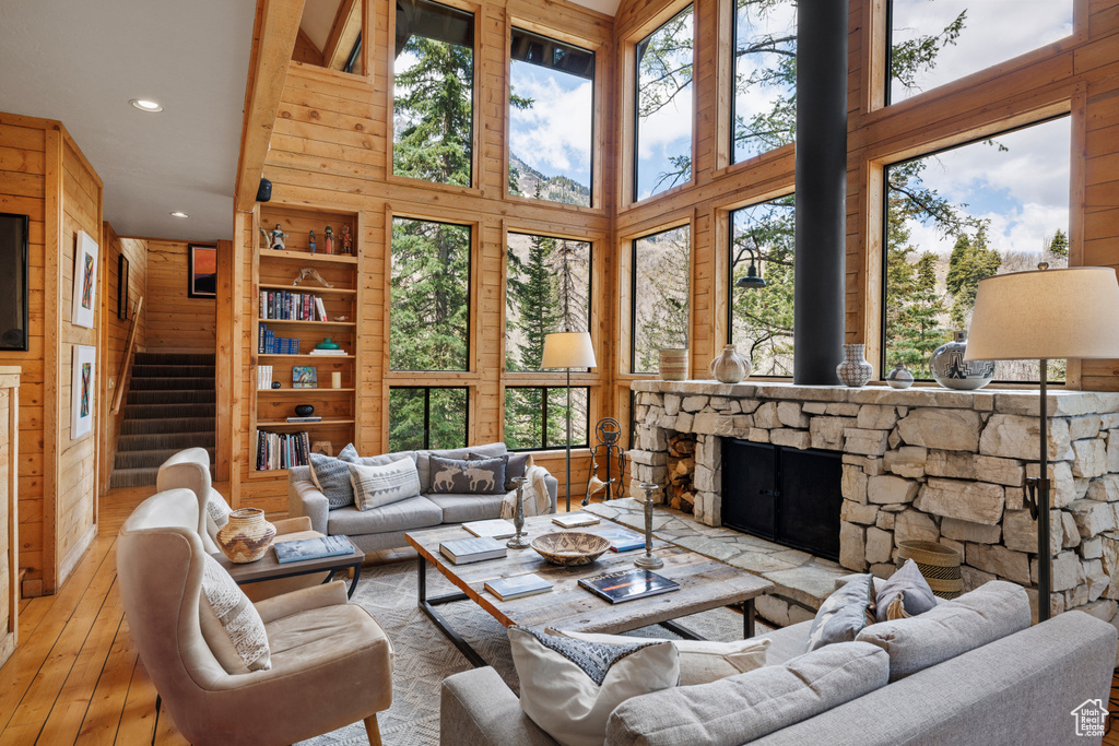Living area featuring recessed lighting, plenty of natural light, stairs, wood-type flooring, and a high ceiling