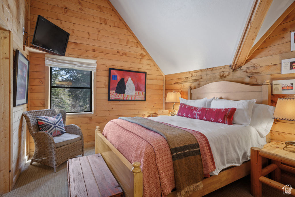Bedroom with wooden walls and lofted ceiling