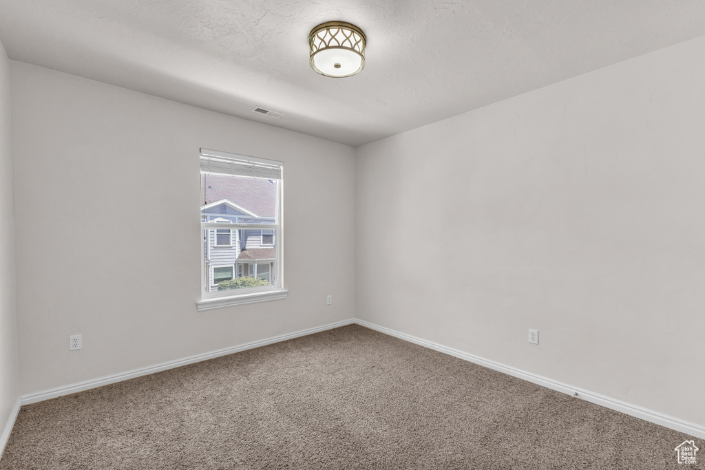 Carpeted spare room with baseboards