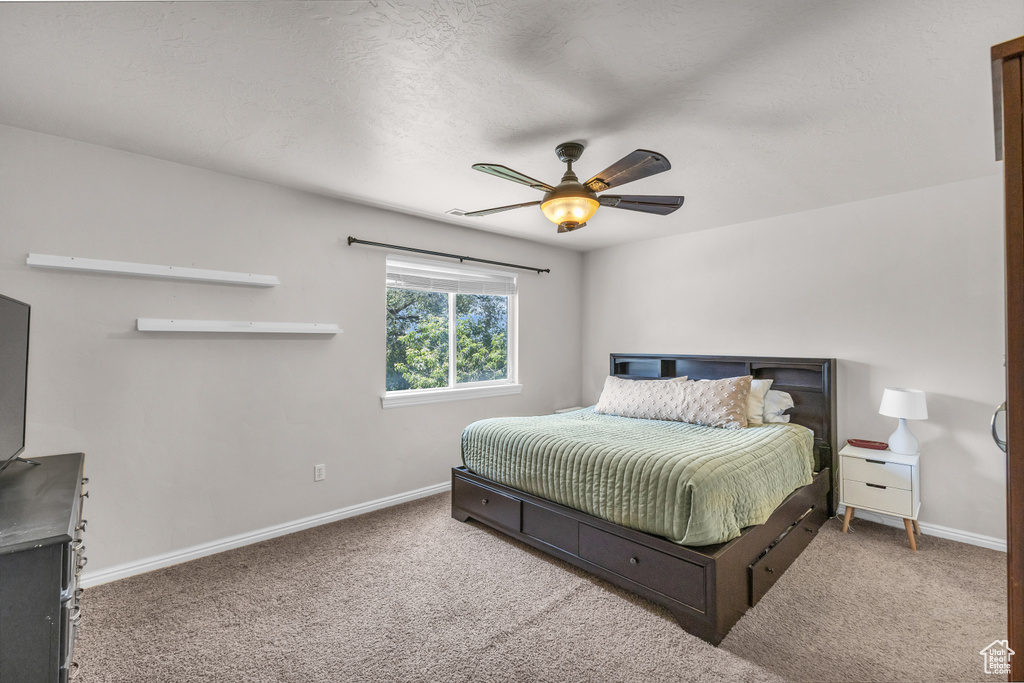 Carpeted bedroom with baseboards and a ceiling fan