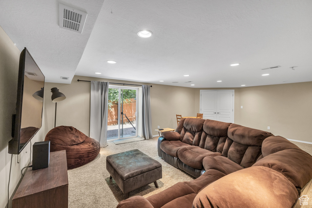 Living area with carpet flooring, recessed lighting, and baseboards