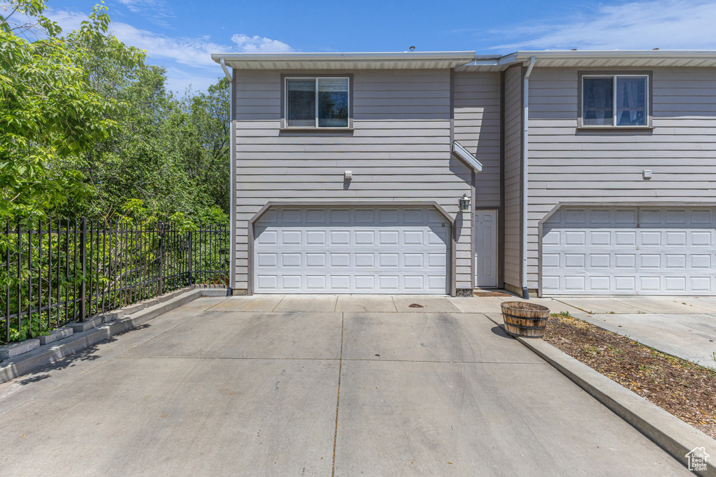 View of front facade featuring a garage and concrete driveway