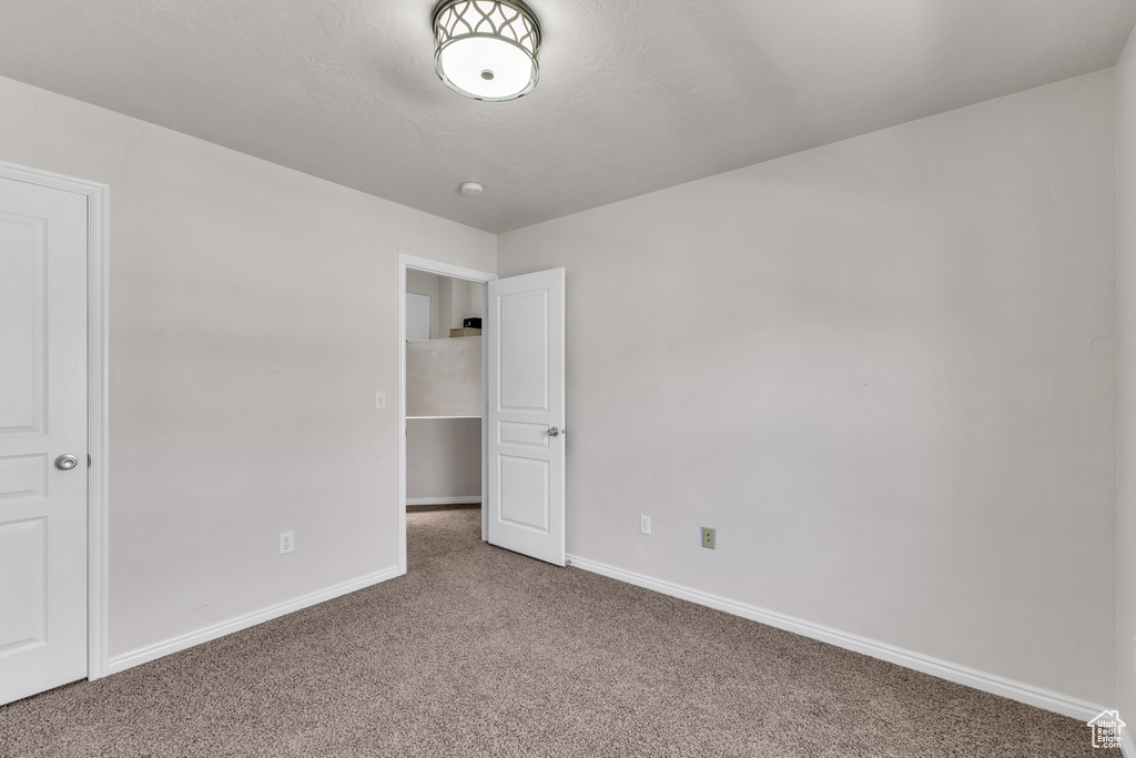 Unfurnished bedroom featuring carpet flooring and baseboards