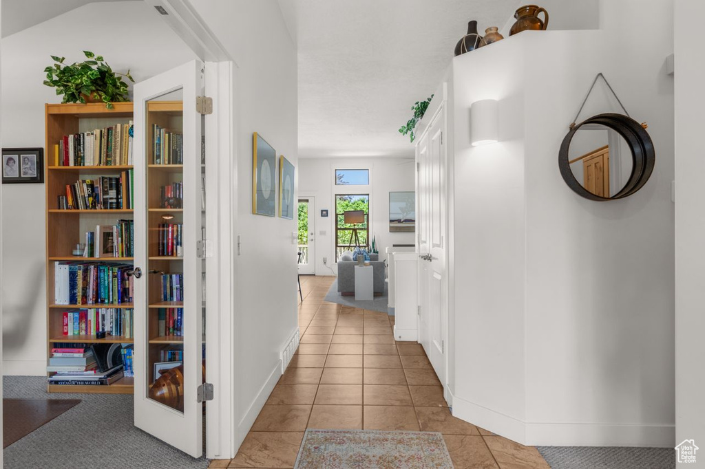 Hallway with baseboards and tile patterned floors