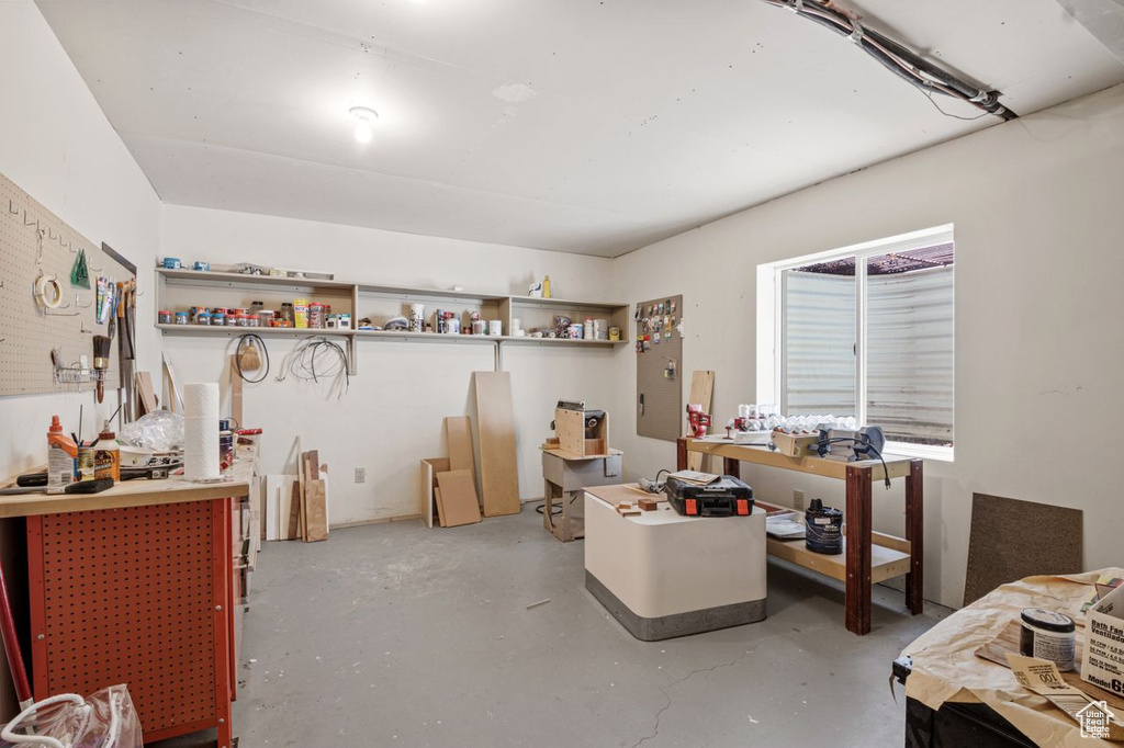 Miscellaneous room with finished concrete flooring and a workshop area