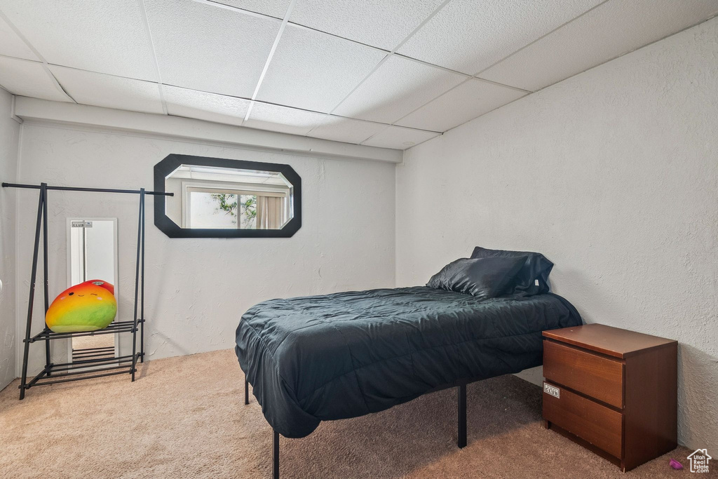 Bedroom featuring carpet and a paneled ceiling