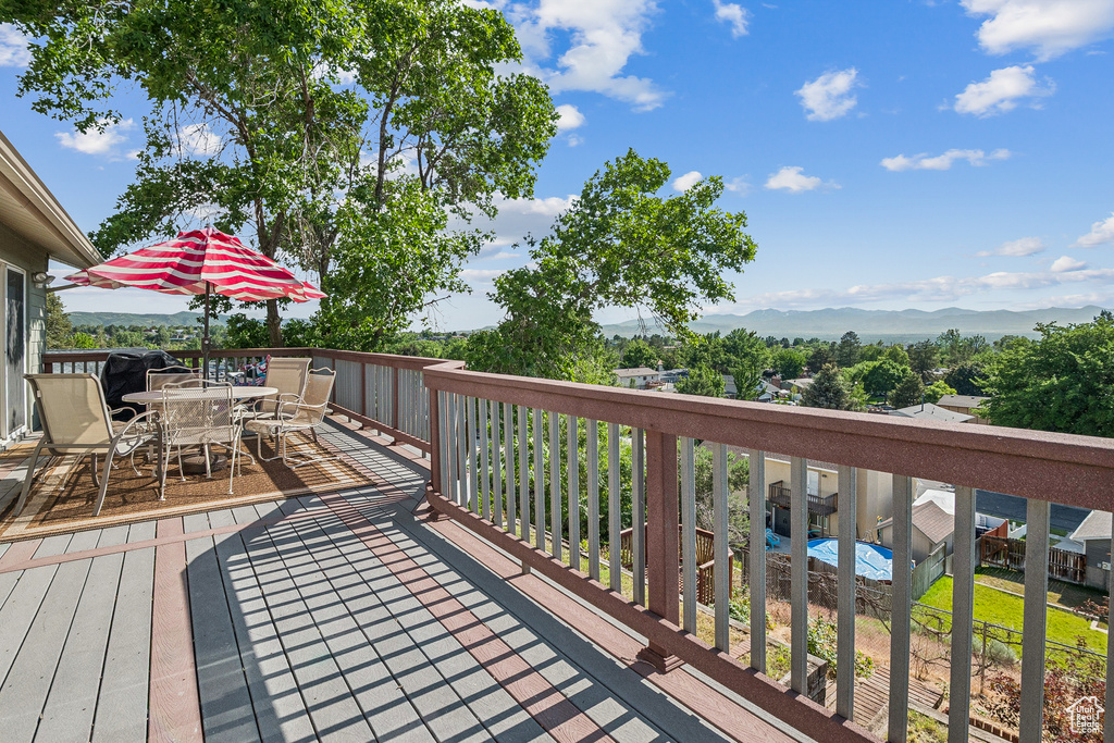 Wooden deck featuring outdoor dining space and a mountain view
