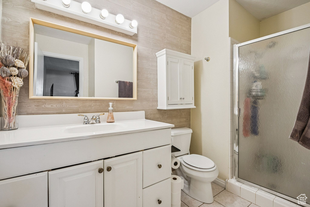 Full bath featuring a shower stall, toilet, vanity, and tile patterned floors