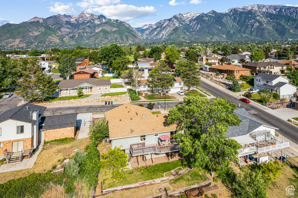 Aerial view of property and surrounding area with nearby suburban area and a mountainous background