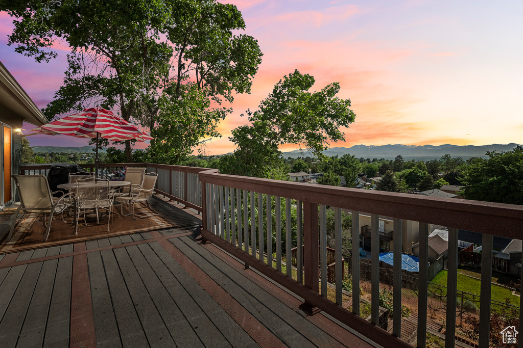 Wooden deck with outdoor dining space and a mountain view