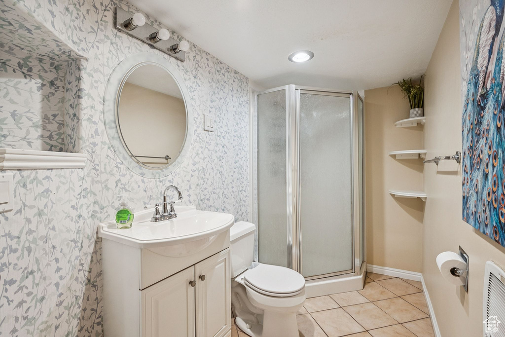 Full bathroom with vanity, a shower stall, tile patterned floors, wallpapered walls, and toilet