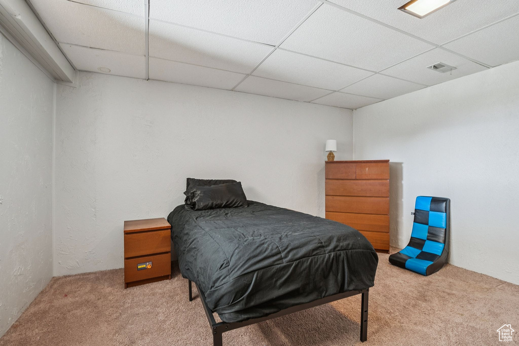 Bedroom featuring a drop ceiling and carpet flooring