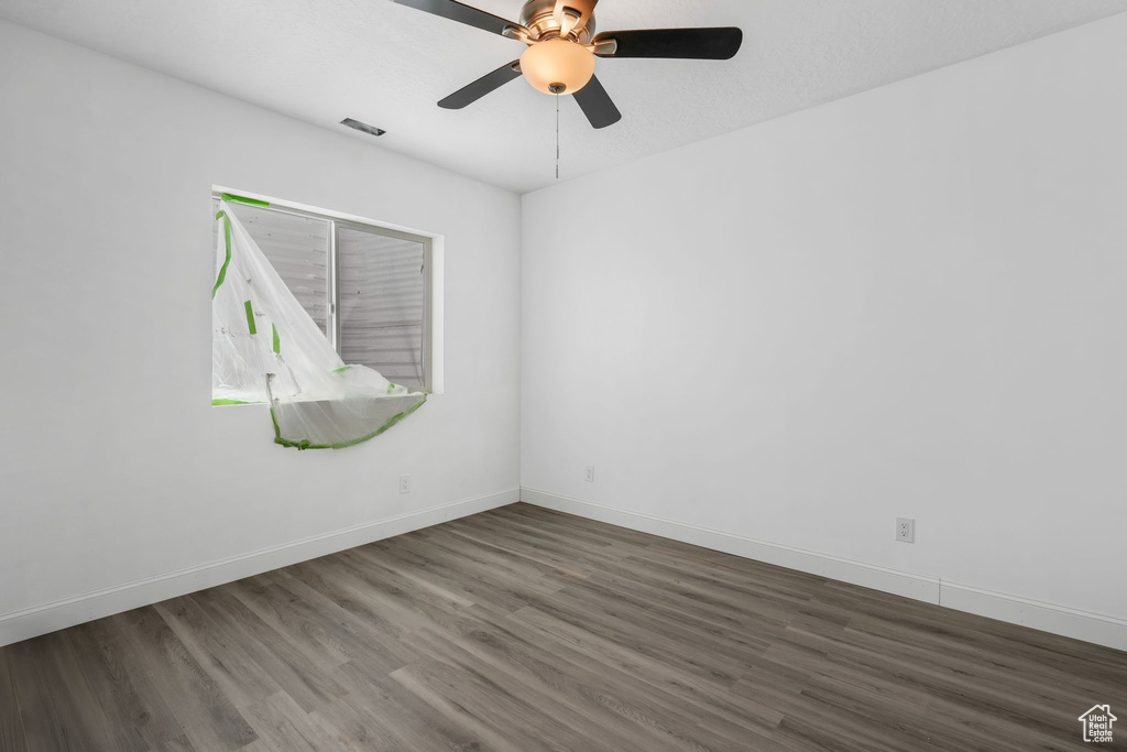 Unfurnished room featuring wood finished floors, baseboards, and a ceiling fan