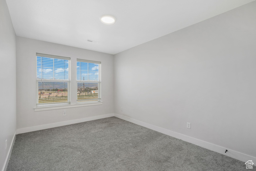 Spare room with carpet and baseboards