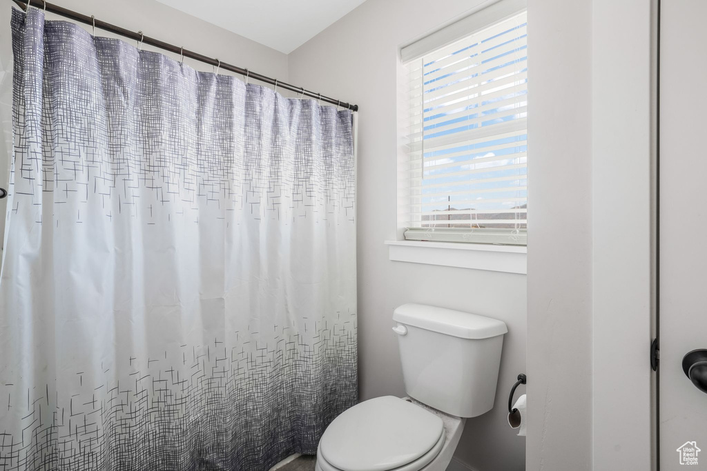 Bathroom with toilet and a shower with shower curtain
