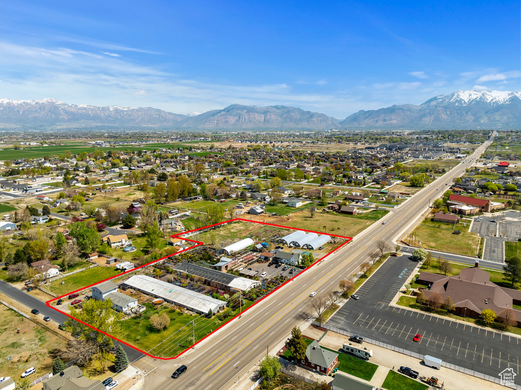 Aerial perspective of suburban area with property parcel outlined and a mountainous background