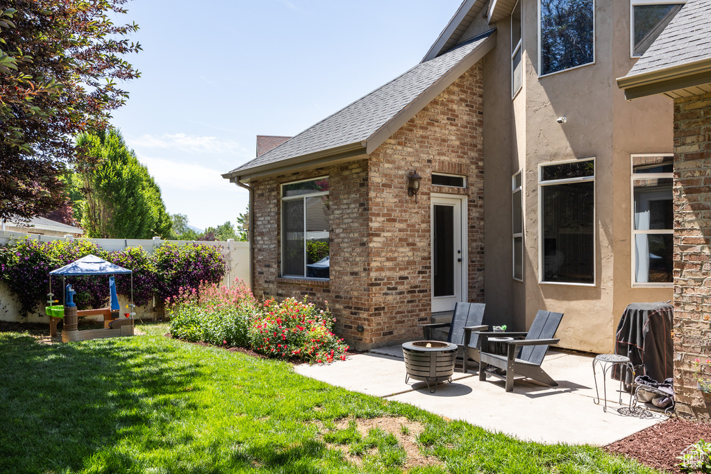 Back of house with a patio area, brick siding, and a shingled roof