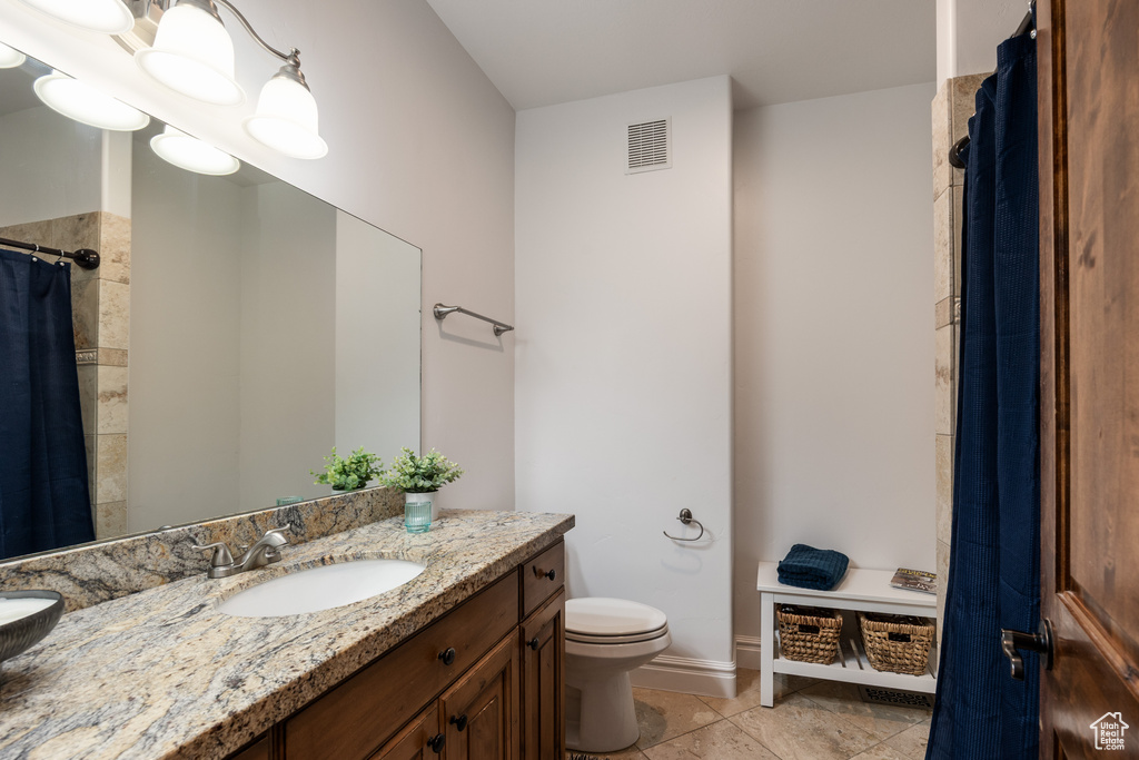 Full bath featuring vanity, toilet, a shower with curtain, baseboards, and tile patterned flooring