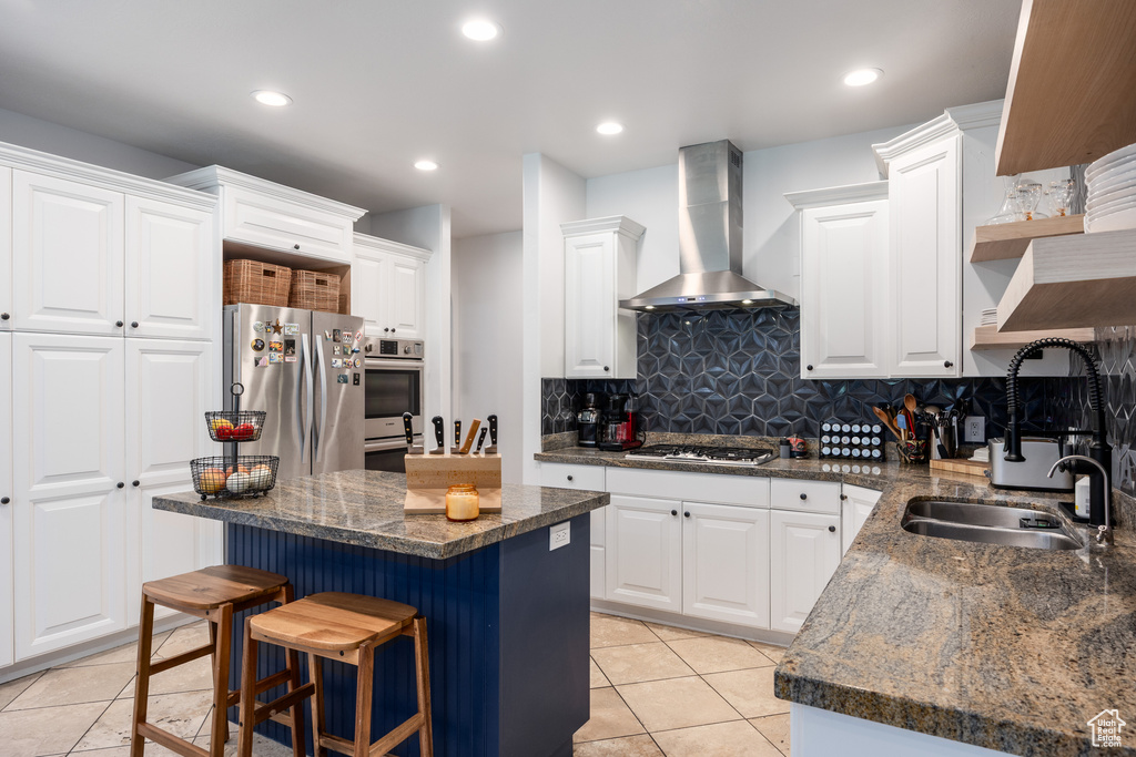 Kitchen featuring extractor fan, stainless steel appliances, a sink, light tile patterned floors, and recessed lighting