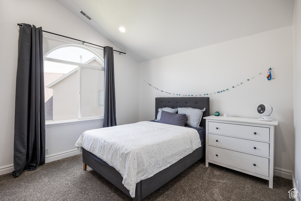 Bedroom with vaulted ceiling, dark carpet, multiple windows, baseboards, and recessed lighting