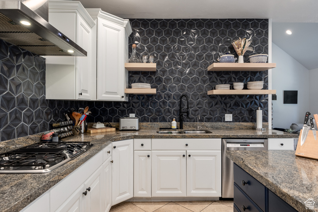 Kitchen featuring open shelves, stainless steel appliances, a sink, wall chimney range hood, and white cabinetry