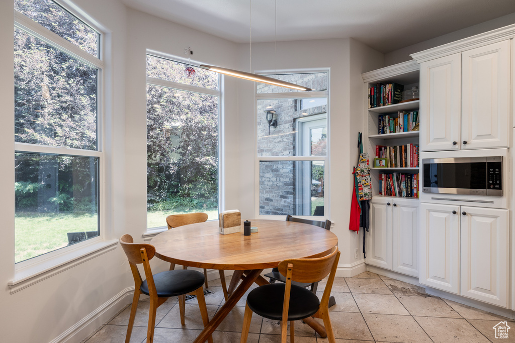 Dining area featuring light tile patterned flooring, plenty of natural light, and baseboards