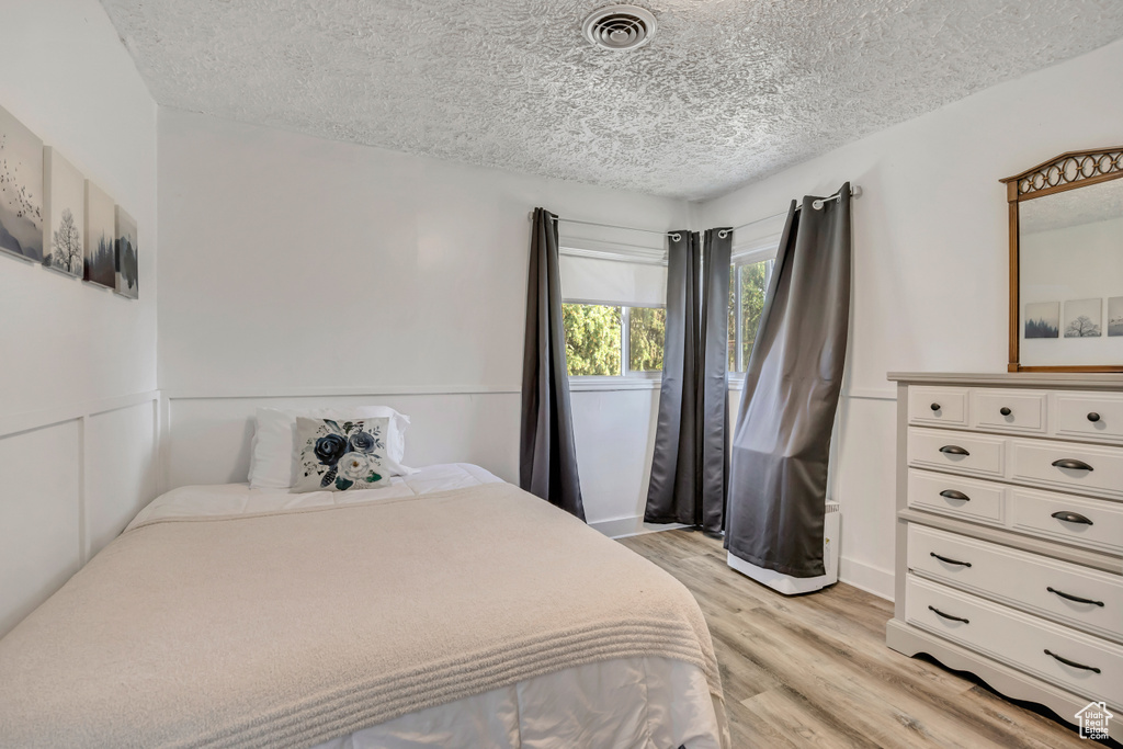 Bedroom featuring light wood-style floors and a textured ceiling