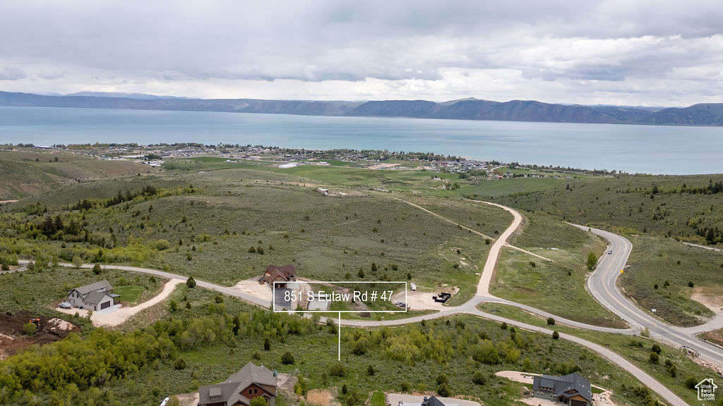 Aerial view of property and surrounding area with a water and mountain view