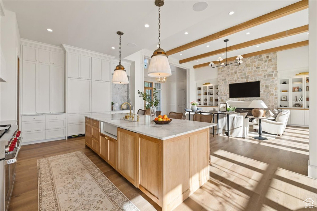 Kitchen featuring a sink, wood finished floors, range with two ovens, recessed lighting, and a chandelier