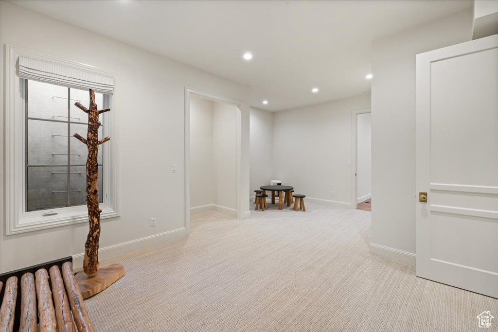 Below grade area with light colored carpet, baseboards, and recessed lighting