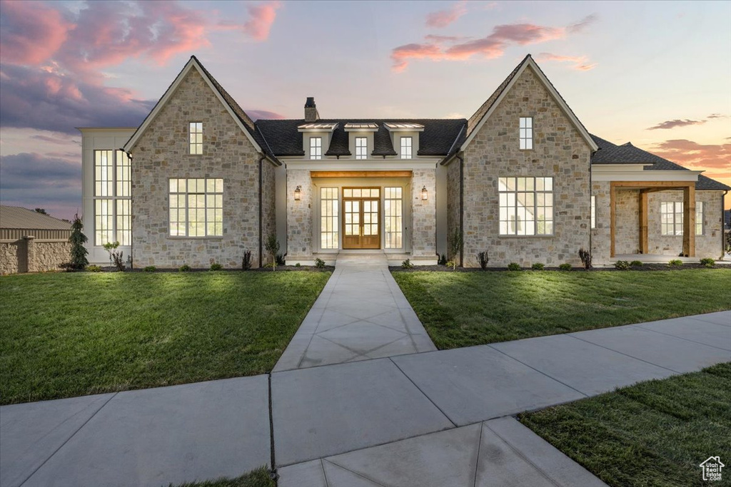 French country home featuring a chimney, french doors, and a front yard