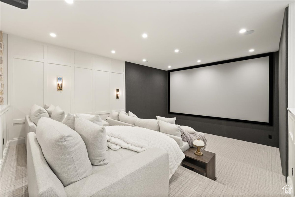 Carpeted home theater featuring a decorative wall and recessed lighting