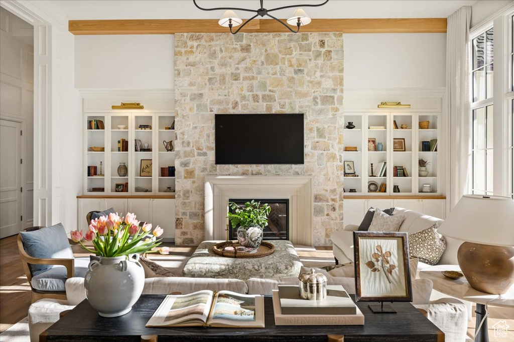 Living area with healthy amount of natural light, a fireplace, a chandelier, and built in features