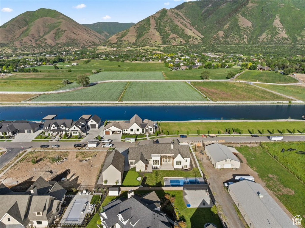 Aerial view of property and surrounding area featuring a water and mountain view and nearby suburban area